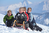 Kinder fahren Schlitten im Familienhotel Sonne Bezau Vorarlberg.