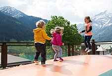 Kinder springen auf einem Trampolin im Familienhotel Alphotel.