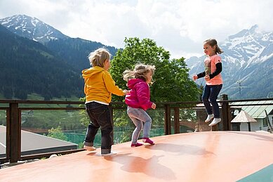 Kinder springen auf einem Trampolin im Familienhotel Alphotel.