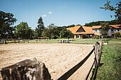 Großer Reitplatz des Familienhotels Landhaus Averbeck in der Lüneburger Heide bei Sonnenschein.