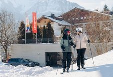 Eltern starten direkt vom Hotel aus zum Skifahren im Familienhotel Amiamo im Salzburger Land.