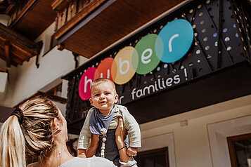 Mutter mit Kleinkind vorm Familienhotel Huber in Südtirol. 