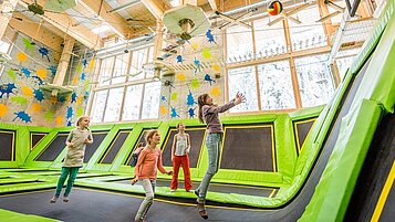 Ein paar Kinder im Trampolinpark beim Basketballspielen im Familienhotel Feldberger Hof im Schwarzwald 