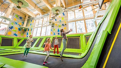 Ein paar Kinder im Trampolinpark beim Basketballspielen im Familienhotel Feldberger Hof im Schwarzwald 