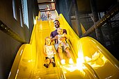 Familie hat riesen freude beim Rutschen der Indoorrutsche des Familienhotels Elldus Resort im Erzgebirge.