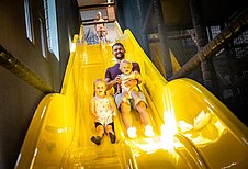 Familie hat riesen freude beim Rutschen der Indoorrutsche des Familienhotels Elldus Resort im Erzgebirge.