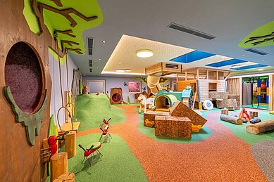 Großer Eltern-Kind-Spielbereich im Familienhotel Huber in Südtirol mit vielen verschiedenen Spielbereichen wie Rutschen und Kletterwänden.
