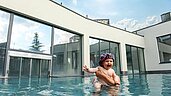 Ein Baby im Pool im Arm seiner Mutter im Familienhotel Ulrichshof im Bayerischen Wald