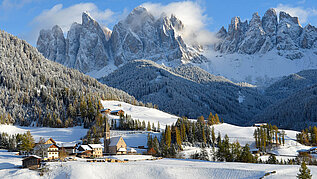 Ein Dort im Winter in einer Berglandschaft.