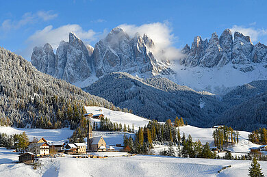 Ein Dort im Winter in einer Berglandschaft.