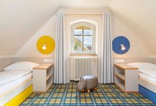 Familienfreundliches Zimmer im Kolping Family Resort in Ungarn: Helle und moderne Einrichtung mit zwei gemütlichen Einzelbetten – perfekt für Kinder.