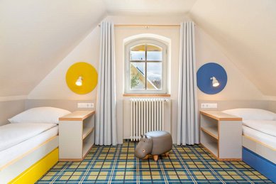 Familienfreundliches Zimmer im Kolping Family Resort in Ungarn: Helle und moderne Einrichtung mit zwei gemütlichen Einzelbetten – perfekt für Kinder.