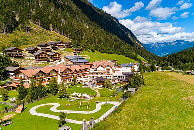 Luftaufnahme im Sommer vom Familienhotel Alphotel Tyrol Wellness & Family Resort in Südtirol.