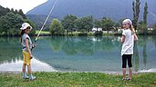 Kinder beim Angeln an einem Teich im Familienhotel Lärchenhof in Tirol