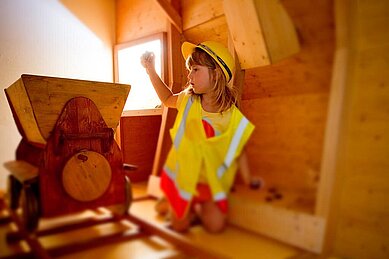 Kind spielt im besonderen Spielbereich "Bergwerk" im Familienhotel Amiamo im Salzburger Land.