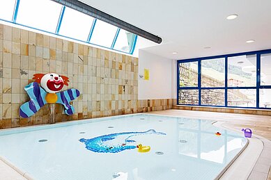 Babybecken mit Wanddeko "Clown" und großen Fenstern im Wellness- & Familienhotel Egger in Saalbach Hinterglemm