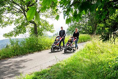 Gäste vom Familienhotel Engel im Schwarzwald gehen Spazieren mit dem Kinderwagen durch die Wälder.