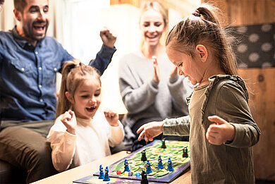 Familie spielt ein Spiel in der Lobby und genießt den Kurzurlaub.