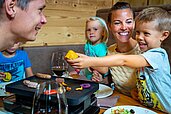 Raclette-Essen für die Familie im Alphotel Tyrol in Südtirol.