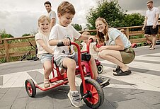 Kind fährt mit dem Dreirad seine Runden auf der Rennstrecke des Familienhotels Seeklause an der Ostsee.