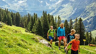Eine Familie mit zwei Kindern beim gemütlichen Wandern im Salzburger Land im Familienurlaub in Österreich.