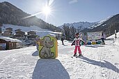 Kinder lernen auf der Hoteleigenen Skipiste des Familienhotels Galtenberg in Tirol das Skifahren in der Kinderskischule.