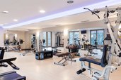 Heller Fitnessraum mit vielen Kraft- und Cardiogeräten im Familienhotel Engel Gourmet & Spa