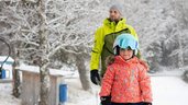 Mädchen lernt Skifahren auf dem Zauberteppich im Familienhotel Der Ponyhof in der Steiermark.