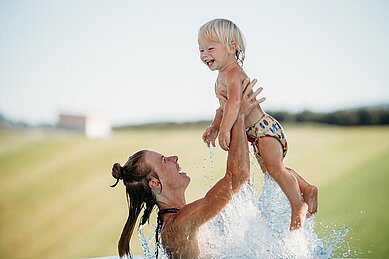 Mutter und Kind haben große freude im Outdoor-Pool des Familienhotels Landhaus zur Ohe im Bayerischen Wald.