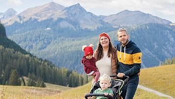 Familie mit Kleinkind und Baby wandert durch die schöne Berglandschaft der Tiroler Zugspitzarena