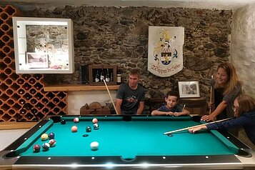 Eine Familie spielt Billard im Kinderhotel Stefan in Pitztal.