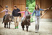 Eine gemeinsame Reitstunde für die Kinder unter Aufsicht von geschultem Reitpersonal im Familienhotel Ottonenhof im Saulerland.