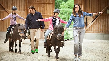 Eine gemeinsame Reitstunde für die Kinder unter Aufsicht von geschultem Reitpersonal im Familienhotel Ottonenhof im Saulerland.