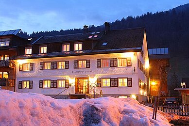 Familienhotel Sonne Bezau in Vorarlberg umgeben von einer winterlichen Landschaft.