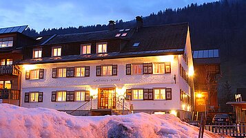 Familienhotel Sonne Bezau in Vorarlberg umgeben von einer winterlichen Landschaft.