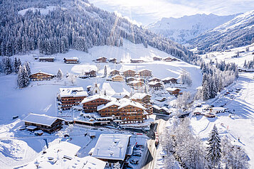 Außenansicht im Winter des Familienhotels Galtenberg Family & Wellness Resort. Das Familienhotel ist eingebettet in eine winterliche Landschaft und liegt in unmittelbarer Nähe zur Skipiste. 