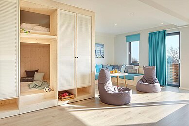 Familienzimmer mit Doppelbett ud Kinderbetten im Entdeckerraum und Sitzsack im Familienhotel Strandkind an der Ostsee