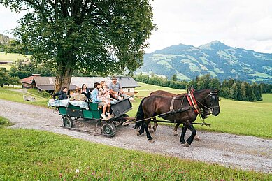 Familie bei einer Kutschfahrt rund um das Familienhotel Das Hopfgarten