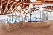 Hallenbad mit ausreichend Liegemöglichkeiten und Strandkörben im Familienhotel Das Hopfgarten in Tirol.