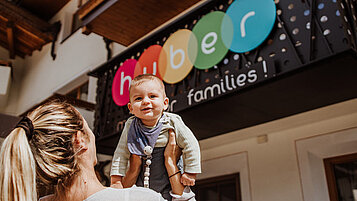 Mutter mit Kleinkind vorm Familienhotel Huber in Südtirol. 