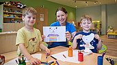 Zwei Kinder malen in der Kinderbetreuung vom Familienhotel Das Bayrischzell in Oberbayern.