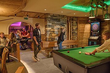 Erwachsene spielen Billard im Familienhotel Zauchenseehof im Salzburger Land