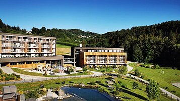 Das Familienhotel Schreinerhof im Bayerischen Wald von außen im Sommer mit einer großen Außenanlage und Outdoor-Spielplatz für Kinder.