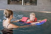 Mutter und Kind schwimmen gemeinsam im Pool des Familienhotels Gorfion