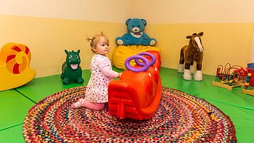 Kleines Mädchen spielt im Happy-Club mit Spielsachen für kleine Kinder im Familienhotel Landhaus zur Ohe im Bayerischen Wald.