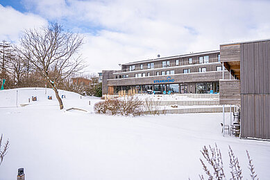 Das Familienhotel Strandkind an der Ostsee in einer verschneiten Umgebung.