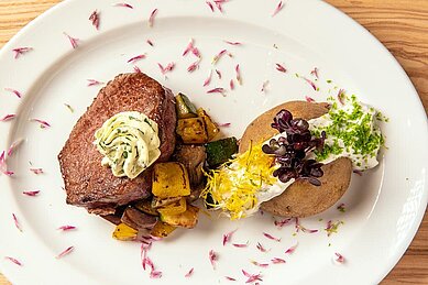 Leckeres Risotto mit Gemüse, angerichtet auf einem weißen Teller im Familienhotel Mein Krug im Fichtelgebirge.