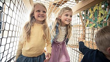 Zwei Mädchen spielen auf dem Indoor-Spielplatz im Familienhotel