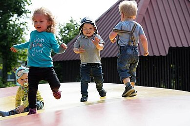 Vier Kinder hüpfen fröhlich auf der Hüpfburg im Landhuus Laurenz.