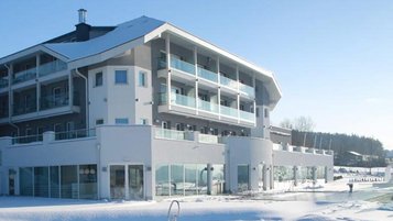 Das Familienhotel Aigo in Oberösterreich im Winter bei herrlichem Sonnenschein.